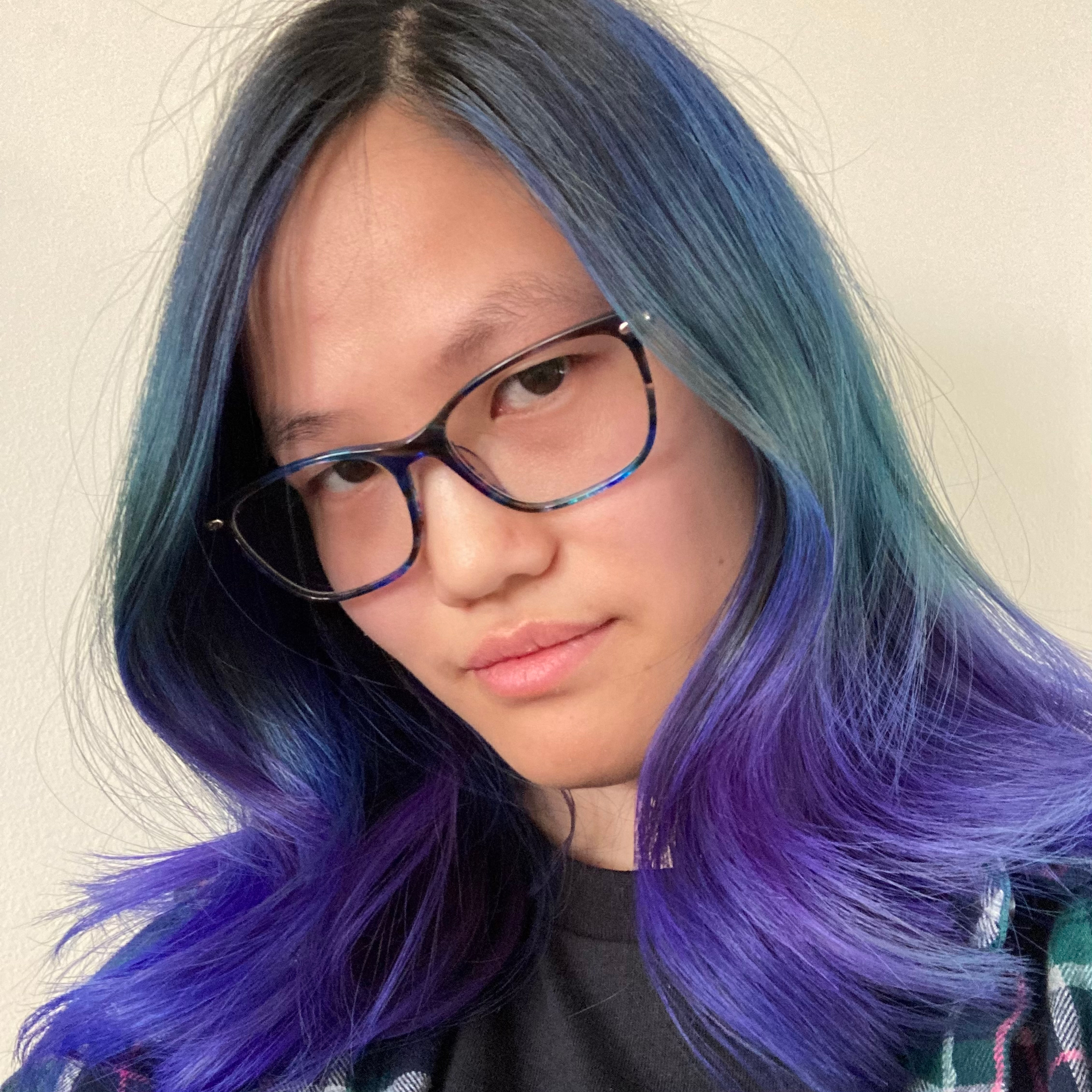 A picture of an Asian woman wearing glasses with teal and purple hair